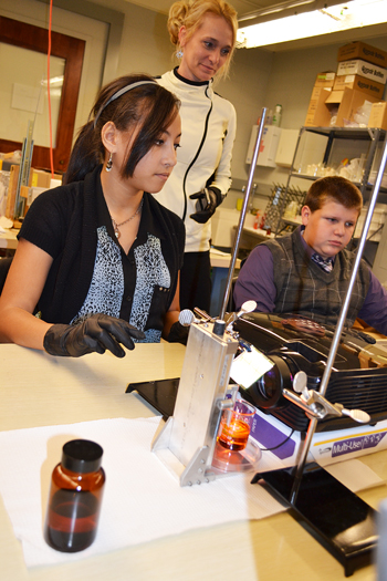 Danville Lutheran science teacher, Kim Wright (center), watches as two of her students do a 3D printing activity in the Mechanical Engineering Lab.